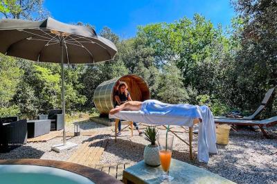 Lit double avec tête de lit en bois sculpté, draps blancs et serviettes pliées, dans une chambre aux murs en pierre.