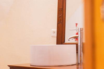 Lit double avec tête de lit en bois sculpté, draps blancs et serviettes pliées, dans une chambre aux murs en pierre.