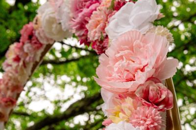 Lit double avec tête de lit en bois sculpté, draps blancs et serviettes pliées, dans une chambre aux murs en pierre.