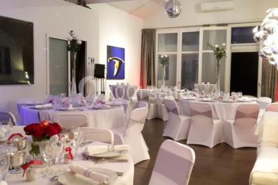 Banquette arrière d'une voiture avec des fleurs blanches et roses disposées sur la plage arrière et un bouquet sur le siège.