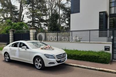 Banquette arrière d'une voiture avec des fleurs blanches et roses disposées sur la plage arrière et un bouquet sur le siège.