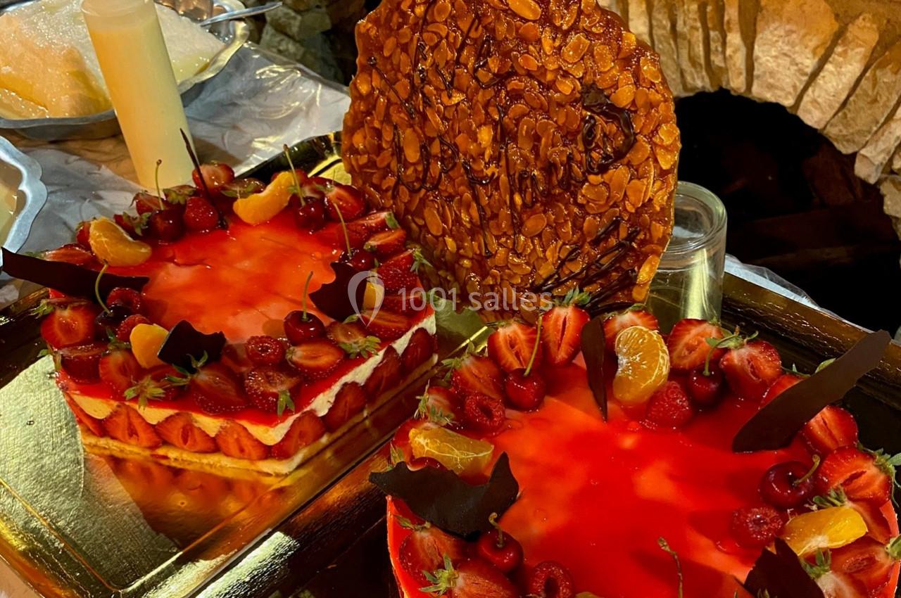 Deux gâteaux aux fraises et oranges décorés de chocolat, avec une tuile aux amandes en arrière-plan.