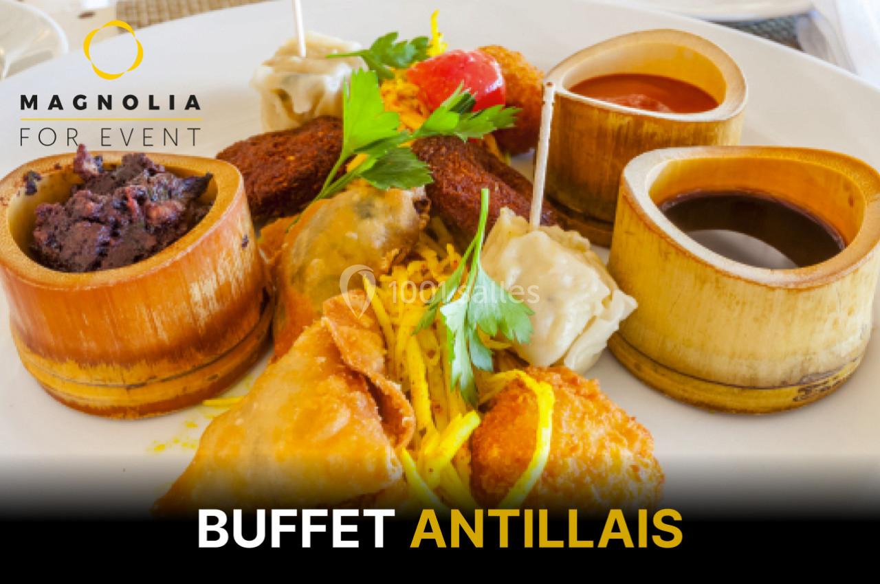 Assortiment de spécialités antillaises présentées sur une assiette, avec sauces et garnitures colorées.