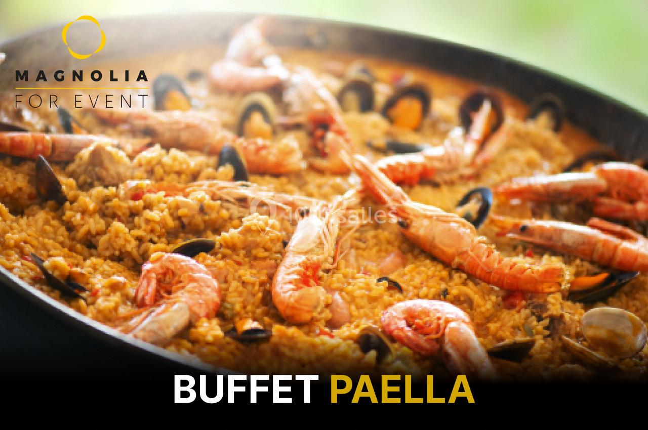 Grande poêle de paella garnie de crevettes, moules et riz safrané, présentée pour un buffet événementiel.