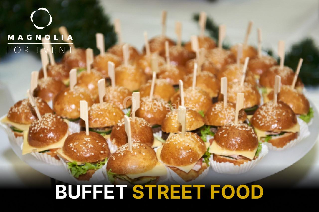 Plateau de mini-burgers garnis de fromage, salade et sauce, présentés avec des piques en bois.