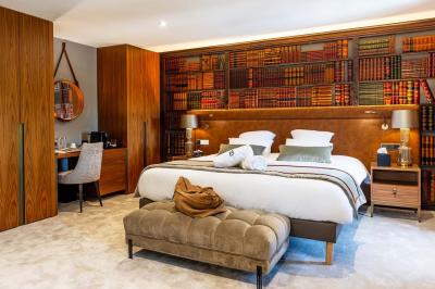 Canapé jaune moutarde capitonné avec coussins noirs, tables basses noires et cadres décoratifs accrochés au mur sombre.