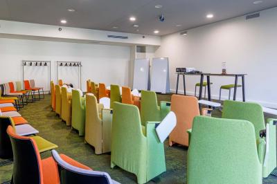 Canapé jaune moutarde capitonné avec coussins noirs, tables basses noires et cadres décoratifs accrochés au mur sombre.