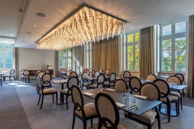 Canapé jaune moutarde capitonné avec coussins noirs, tables basses noires et cadres décoratifs accrochés au mur sombre.