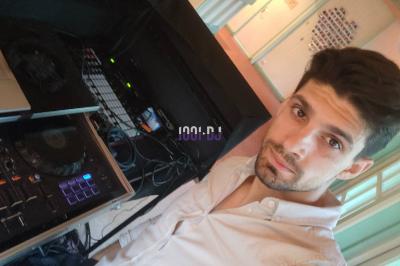 Vue d'une salle de réception avec des tables alignées, un bar en bois et un éclairage chaleureux sous une arche.