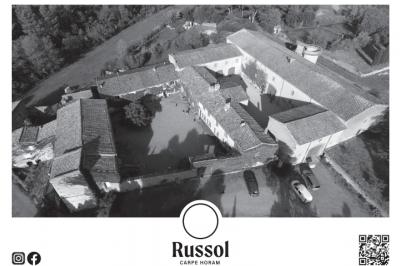 Des personnes assises dans une salle assistent à une présentation projetée sur un mur, avec documents en main.