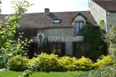 Deux structures gonflables colorées installées sur une pelouse, près de bâtiments en pierre et en bois.