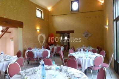 Deux structures gonflables colorées installées sur une pelouse, près de bâtiments en pierre et en bois.