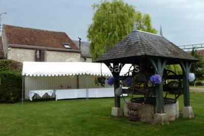 Deux structures gonflables colorées installées sur une pelouse, près de bâtiments en pierre et en bois.