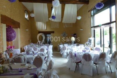 Deux structures gonflables colorées installées sur une pelouse, près de bâtiments en pierre et en bois.