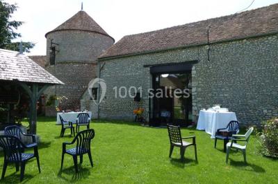 Deux structures gonflables colorées installées sur une pelouse, près de bâtiments en pierre et en bois.