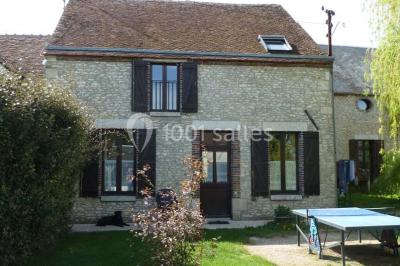 Deux structures gonflables colorées installées sur une pelouse, près de bâtiments en pierre et en bois.