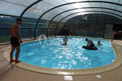 Deux structures gonflables colorées installées sur une pelouse, près de bâtiments en pierre et en bois.