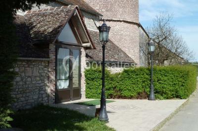Deux structures gonflables colorées installées sur une pelouse, près de bâtiments en pierre et en bois.