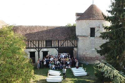 Deux structures gonflables colorées installées sur une pelouse, près de bâtiments en pierre et en bois.