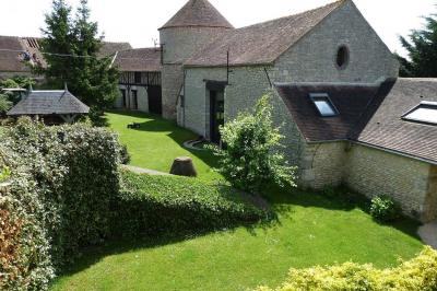 Deux structures gonflables colorées installées sur une pelouse, près de bâtiments en pierre et en bois.