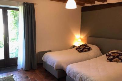 Deux structures gonflables colorées installées sur une pelouse, près de bâtiments en pierre et en bois.