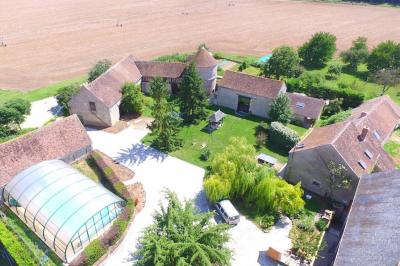 Deux structures gonflables colorées installées sur une pelouse, près de bâtiments en pierre et en bois.