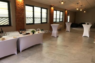 Bâtiment en briques rouges avec une allée bordée de pelouses et des drapeaux visibles au loin sous un ciel dégagé.