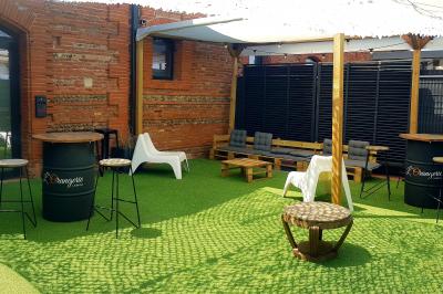 Bâtiment en briques rouges avec une allée bordée de pelouses et des drapeaux visibles au loin sous un ciel dégagé.