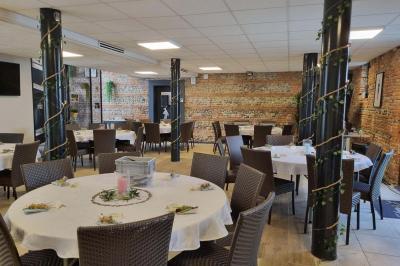 Bâtiment en briques rouges avec une allée bordée de pelouses et des drapeaux visibles au loin sous un ciel dégagé.