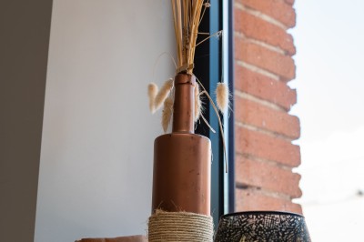 Bâtiment en briques rouges avec une allée bordée de pelouses et des drapeaux visibles au loin sous un ciel dégagé.