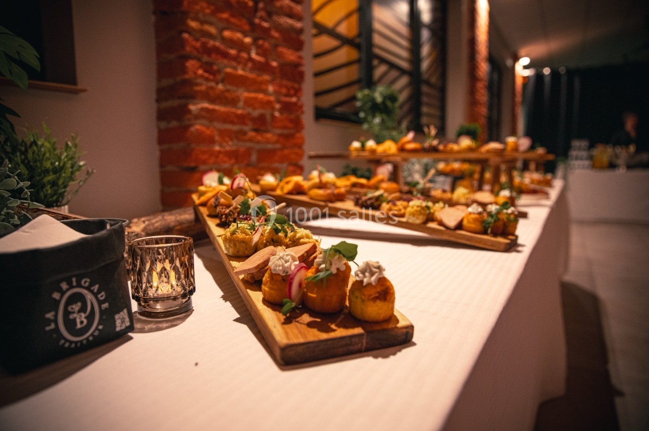 Buffet de petits plats variés disposés sur des planches en bois, dans une salle à la décoration chaleureuse.