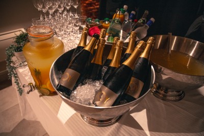 Bâtiment en briques rouges avec une allée bordée de pelouses et des drapeaux visibles au loin sous un ciel dégagé.