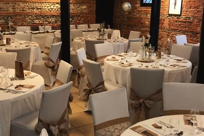 Salle lumineuse avec murs en briques, tables hautes, fauteuil jaune et décorations minimalistes.