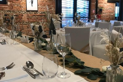 Salle lumineuse avec murs en briques, tables hautes, fauteuil jaune et décorations minimalistes.