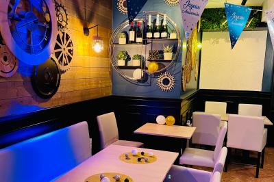 Salle de bar avec tables hautes, chaises, éclairage coloré et jeux de lumière dans une ambiance nocturne.