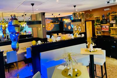 Salle de bar avec tables hautes, chaises, éclairage coloré et jeux de lumière dans une ambiance nocturne.