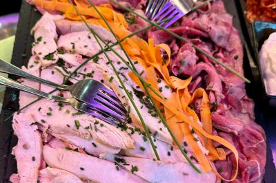 Salle de bar avec tables hautes, chaises, éclairage coloré et jeux de lumière dans une ambiance nocturne.