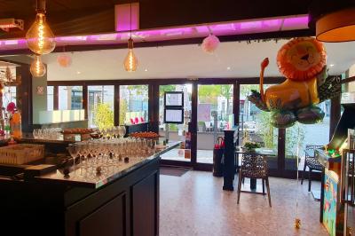 Salle de bar avec tables hautes, chaises, éclairage coloré et jeux de lumière dans une ambiance nocturne.