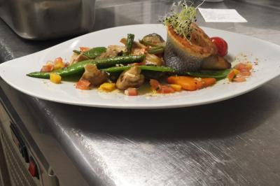 Verrine de dessert composée de crème fouettée, morceaux de pêche et coulis de mangue sur un lit de biscuit.