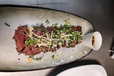 Verrine de dessert composée de crème fouettée, morceaux de pêche et coulis de mangue sur un lit de biscuit.