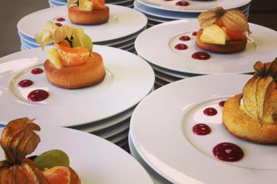 Table de buffet décorée avec des fleurs, chandeliers allumés, coupes empilées et divers plats dans une ambiance lumineuse…