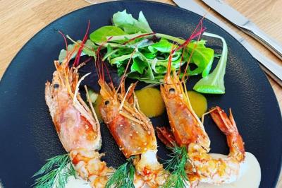 Table de buffet décorée avec des fleurs, chandeliers allumés, coupes empilées et divers plats dans une ambiance lumineuse…