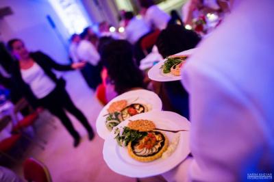 Table de buffet décorée avec des fleurs, chandeliers allumés, coupes empilées et divers plats dans une ambiance lumineuse…