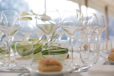 Table dressée avec des verres en cristal, une décoration végétale et des petits pains sur des assiettes blanches.