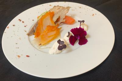 Table décorée pour un buffet avec chandeliers, fleurs, coupes empilées et divers plats dans une ambiance lumineuse violette.