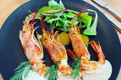 Table décorée pour un buffet avec chandeliers, fleurs, coupes empilées et divers plats dans une ambiance lumineuse violette.
