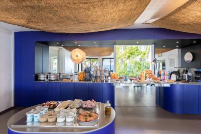 Crevettes grillées servies dans une assiette bleue avec des herbes, accompagnées de plats et d'un verre de vin rouge.