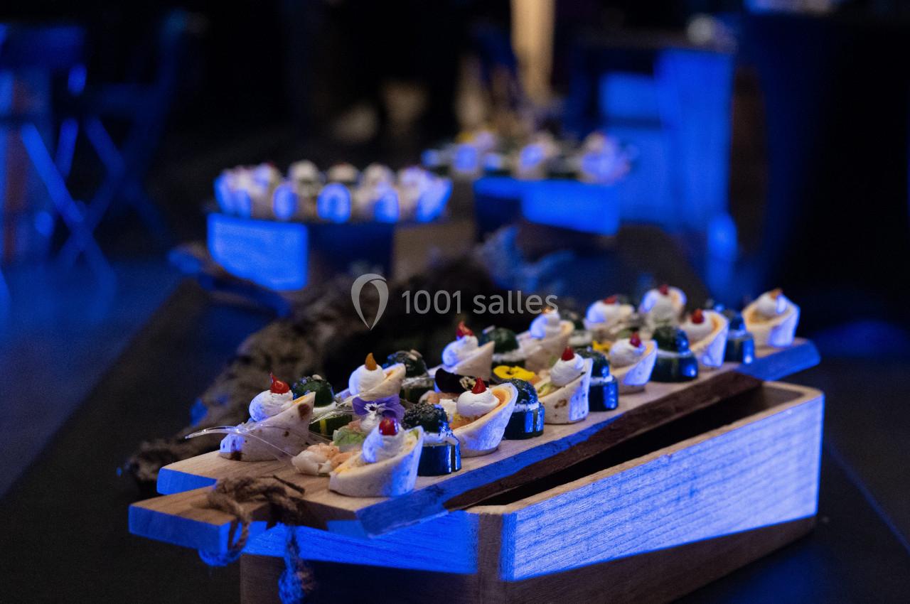 Plateau de bouchées apéritives élégamment présentées sur une table dans une ambiance tamisée.