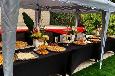 Cuisine professionnelle équipée avec four, réfrigérateur, plan de travail en inox et hotte d'extraction.