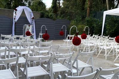 Cuisine professionnelle équipée avec four, réfrigérateur, plan de travail en inox et hotte d'extraction.